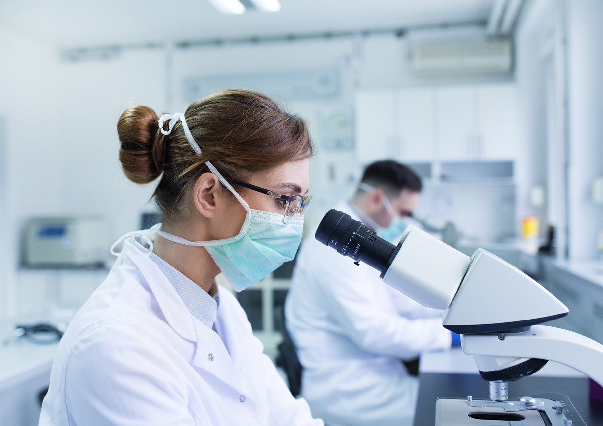 Biologists working with microscope